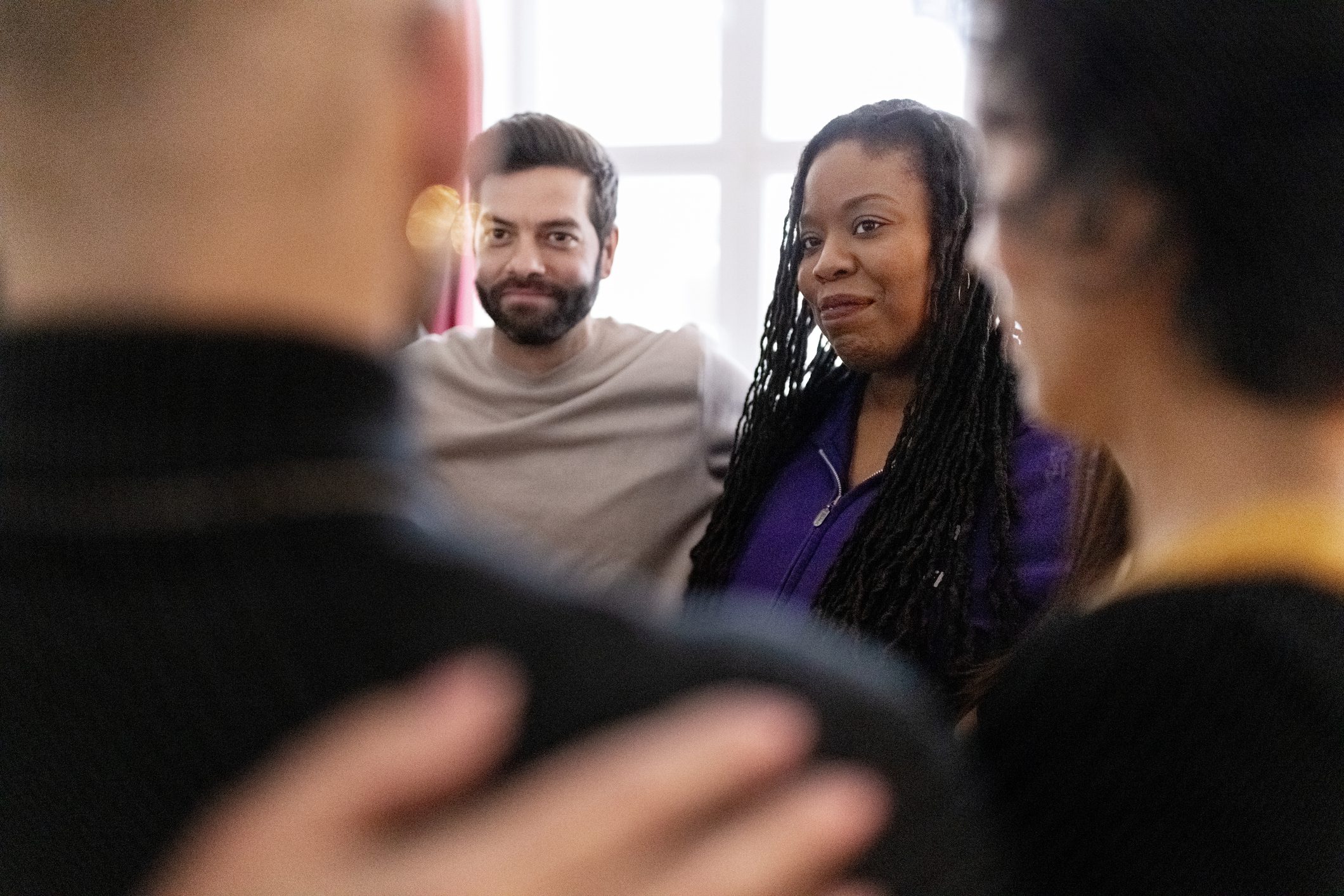 Diverse group of people standing in a huddle during therapy session.